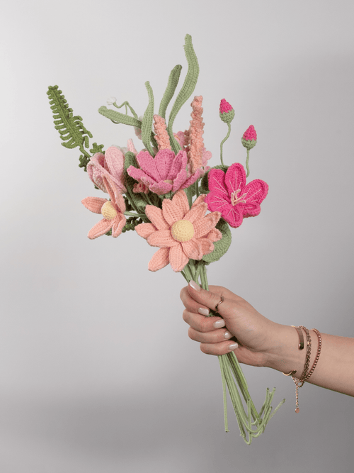 Der Blumenstrauß Peach Blossom wird in der Hand gehalten. Ein Produktbild des bloomly Strauß mit grauem Hintergrund