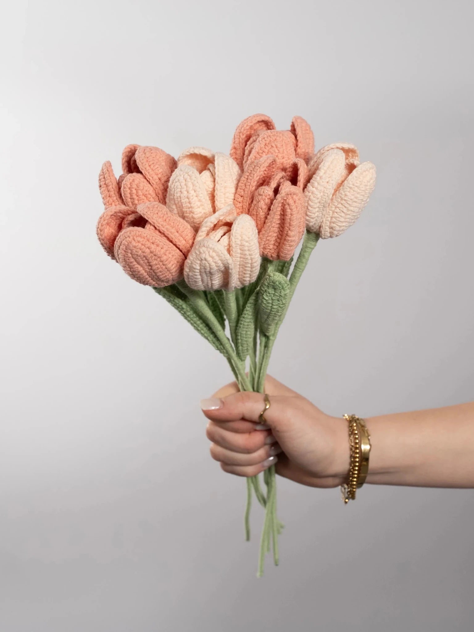 Der Blumenstrauß Tulip Dream wird in der Hand gehalten. Ein Produktbild des bloomly Strauß mit grauem Hintergrund